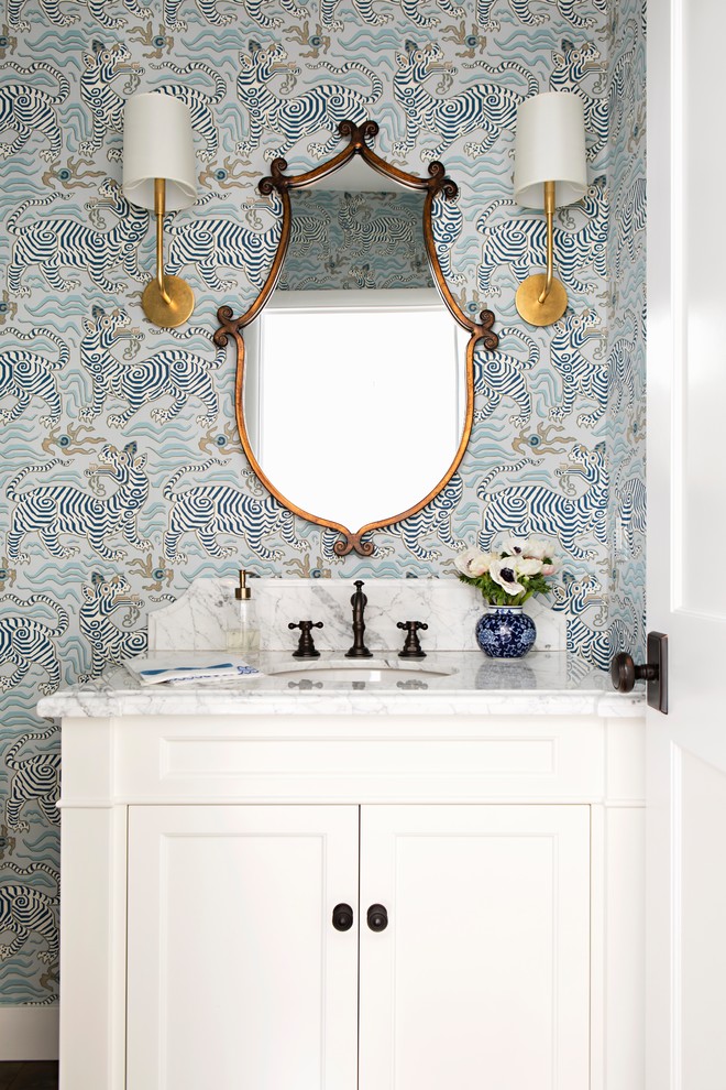 Inspiration for a small transitional powder room in Los Angeles with white cabinets, a one-piece toilet, multi-coloured walls, dark hardwood floors, an undermount sink, marble benchtops, brown floor, recessed-panel cabinets and white benchtops.