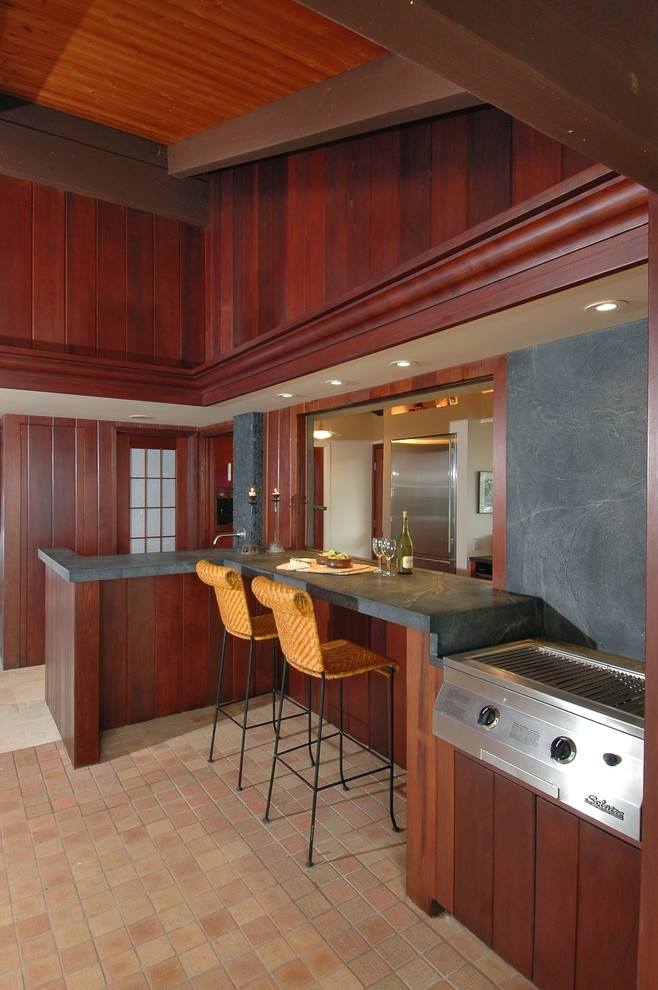 This is an example of a tropical kitchen in Hawaii with dark wood cabinets.