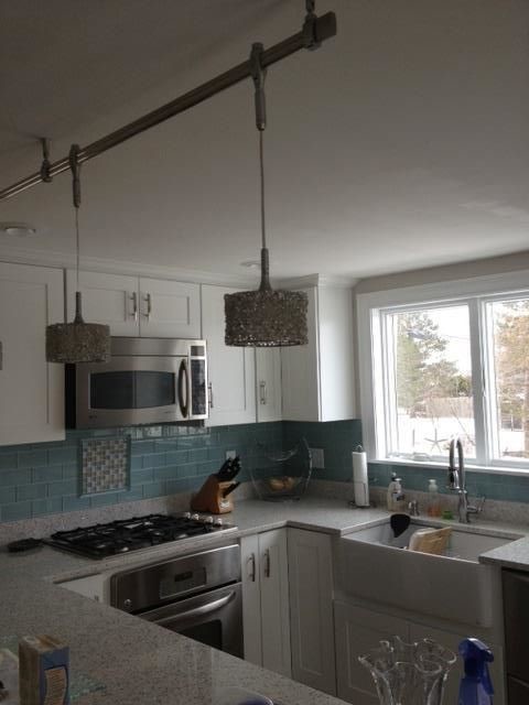 Eat-in kitchen - transitional u-shaped eat-in kitchen idea in Boston with a drop-in sink, recessed-panel cabinets, white cabinets, granite countertops, blue backsplash, mosaic tile backsplash, stainless steel appliances and no island