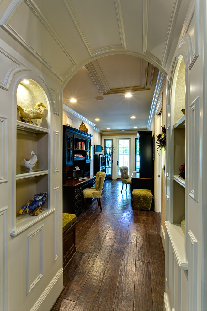 Photo of a large traditional hallway in Orange County with dark hardwood floors, beige walls and brown floor.