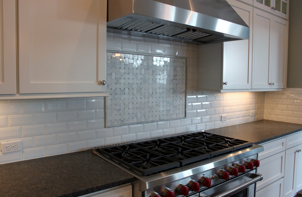 Inspiration for a transitional dark wood floor kitchen remodel in Seattle with shaker cabinets, white cabinets, quartzite countertops, white backsplash, ceramic backsplash and stainless steel appliances