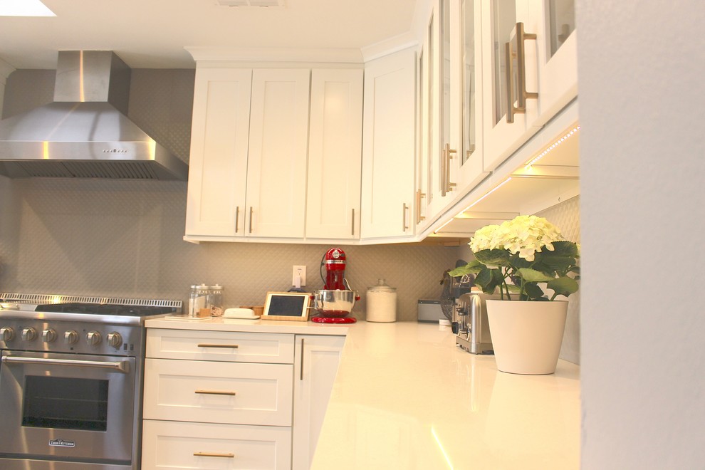Example of a large transitional l-shaped ceramic tile and beige floor open concept kitchen design in Phoenix with an undermount sink, shaker cabinets, white cabinets, quartzite countertops, gray backsplash, stainless steel appliances and an island