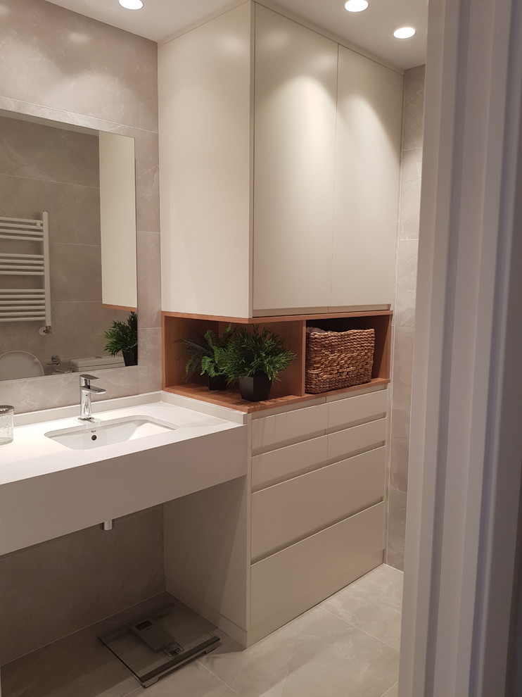 Foto de cuarto de baño principal minimalista de tamaño medio con puertas de armario blancas, baldosas y/o azulejos grises, paredes grises, lavabo suspendido, suelo gris y encimeras blancas