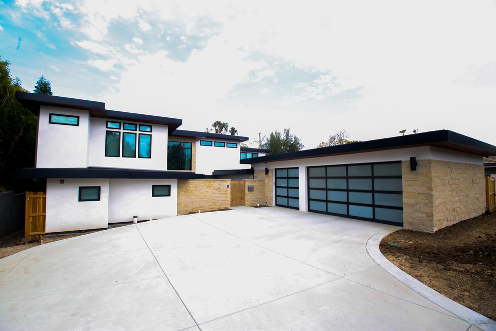 This is an example of a large contemporary two-storey stucco white house exterior in Los Angeles with a flat roof.