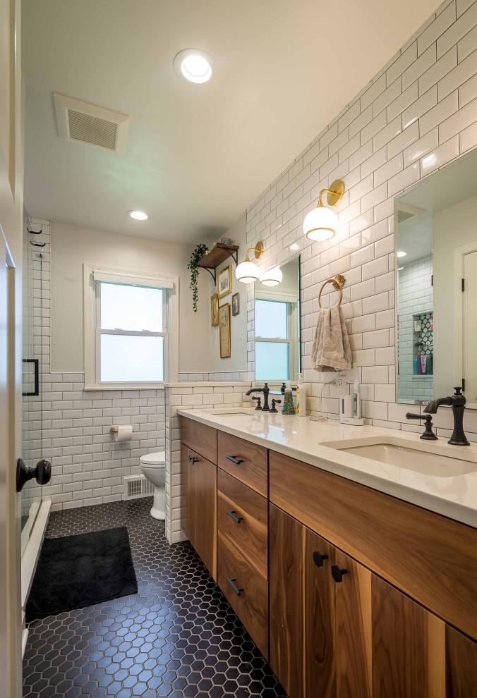 Design ideas for a mid-sized midcentury master bathroom in Chicago with beaded inset cabinets, medium wood cabinets, an alcove shower, a one-piece toilet, white tile, subway tile, white walls, ceramic floors, an undermount sink, quartzite benchtops, black floor, a sliding shower screen, white benchtops, a double vanity, a freestanding vanity, wallpaper and wallpaper.