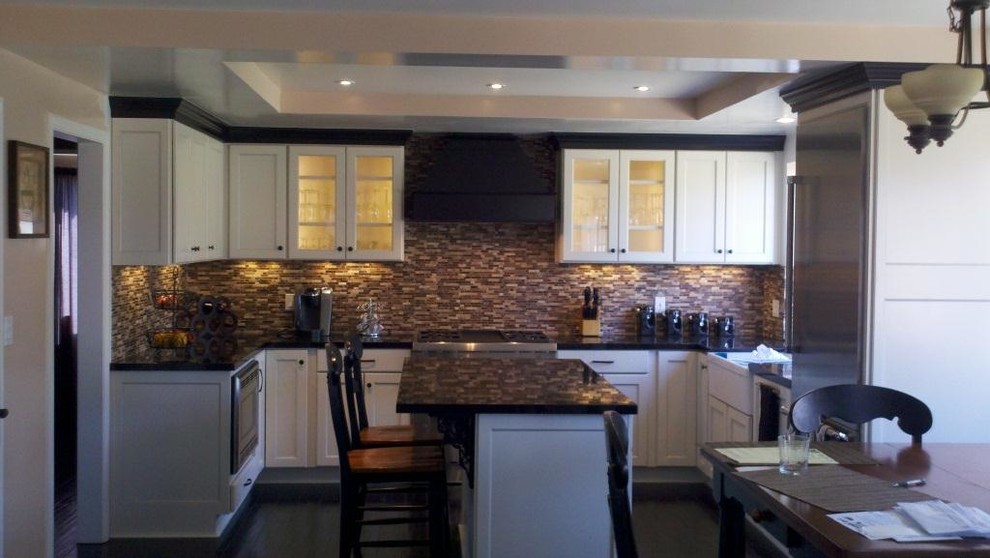 This is an example of a mid-sized contemporary u-shaped eat-in kitchen in San Luis Obispo with a farmhouse sink, shaker cabinets, yellow cabinets, quartz benchtops, multi-coloured splashback, glass tile splashback, stainless steel appliances and with island.