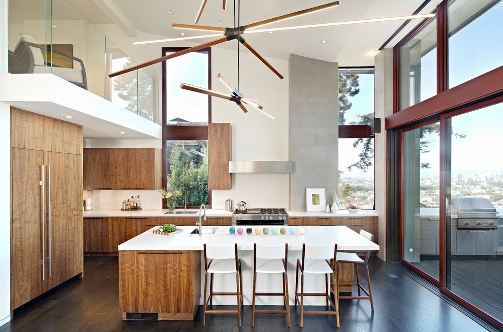Large contemporary l-shaped eat-in kitchen in San Francisco with an undermount sink, flat-panel cabinets, beige splashback, dark hardwood floors, with island, white benchtop, dark wood cabinets, quartz benchtops, stainless steel appliances and grey floor.