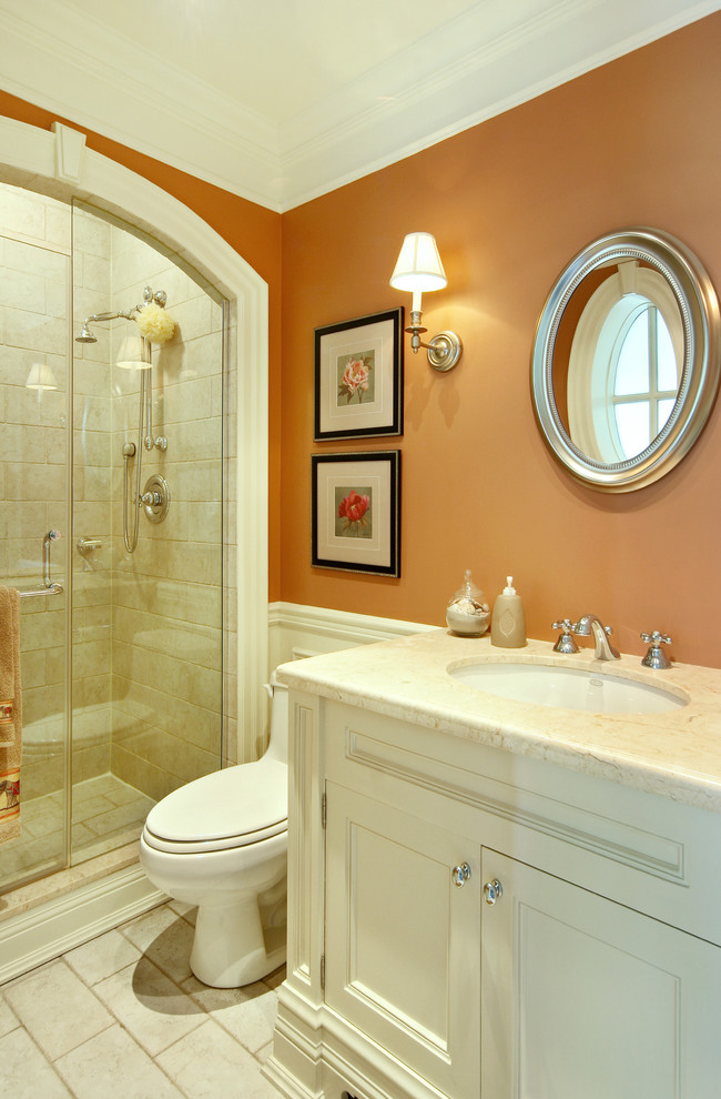 Mid-sized traditional 3/4 bathroom in Toronto with stone tile, orange walls, white cabinets, an alcove shower, a one-piece toilet, porcelain floors, an undermount sink, marble benchtops and recessed-panel cabinets.