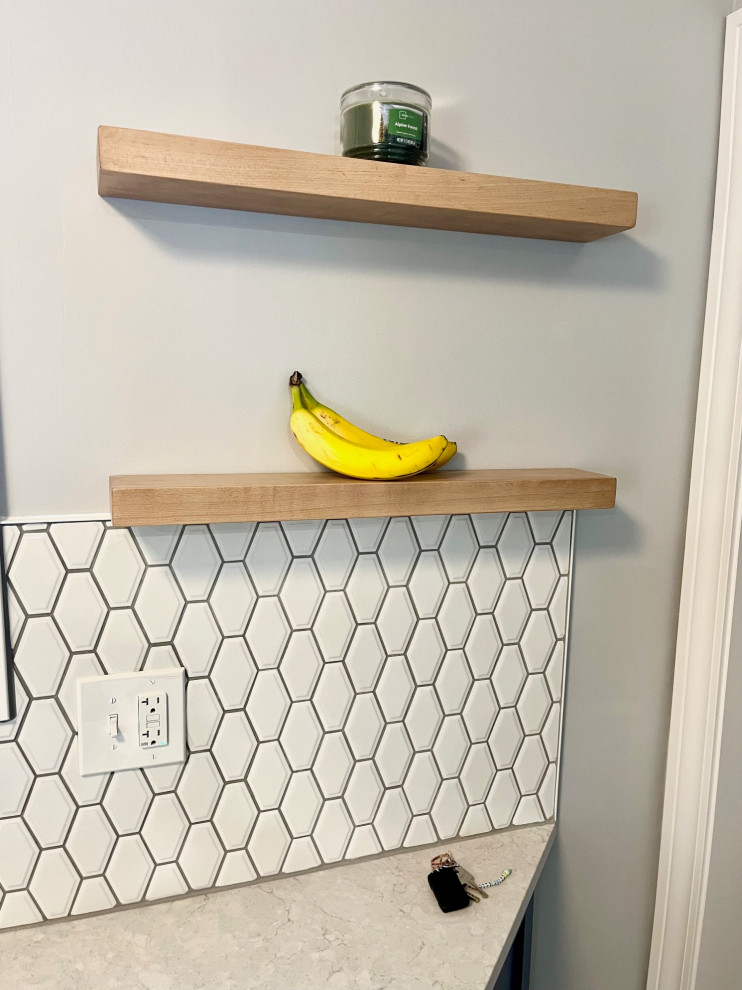 Mid-sized transitional u-shaped vinyl floor and brown floor eat-in kitchen photo with an undermount sink, shaker cabinets, white cabinets, quartz countertops, white backsplash, ceramic backsplash, stainless steel appliances, no island and white countertops
