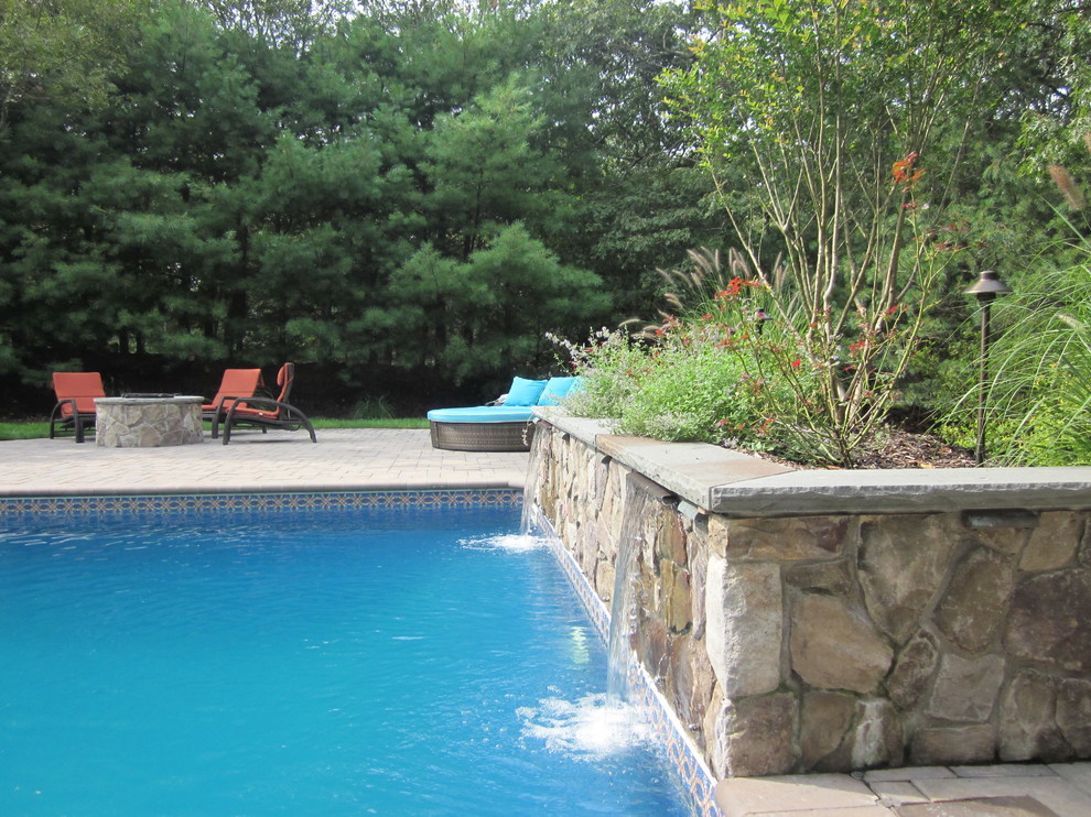 Inspiration for a mid-sized traditional backyard rectangular natural pool in New York with concrete pavers and a hot tub.