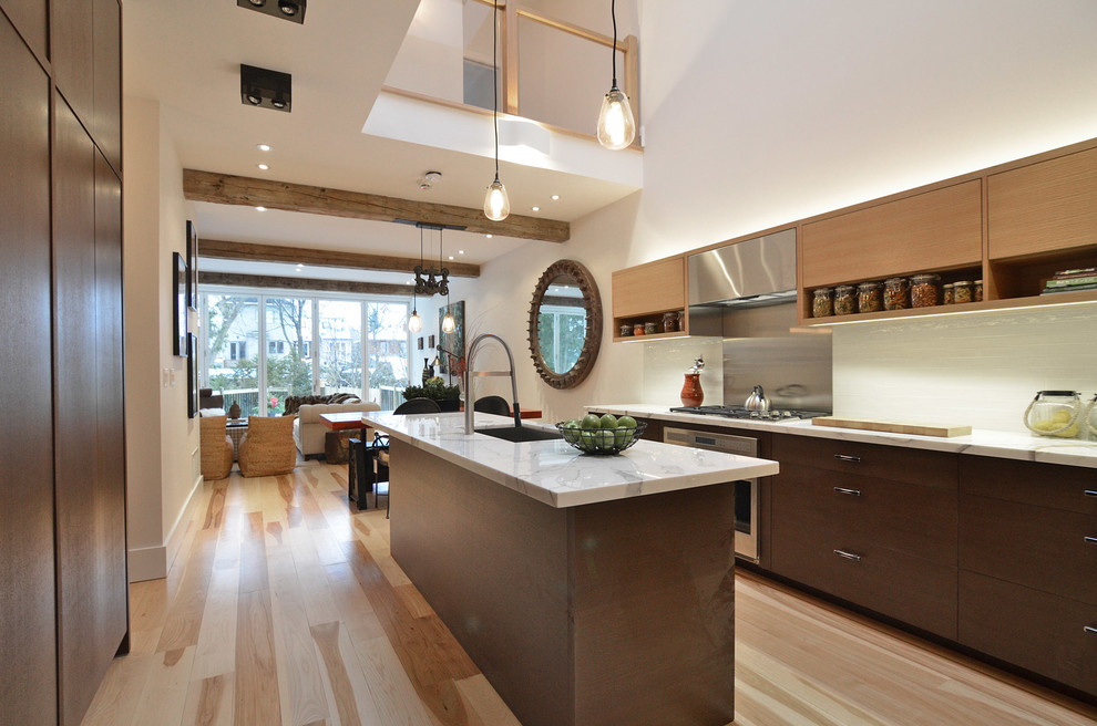 Mid-sized galley light wood floor open concept kitchen photo in Toronto with an undermount sink, flat-panel cabinets, dark wood cabinets, marble countertops, white backsplash, glass tile backsplash, stainless steel appliances and an island