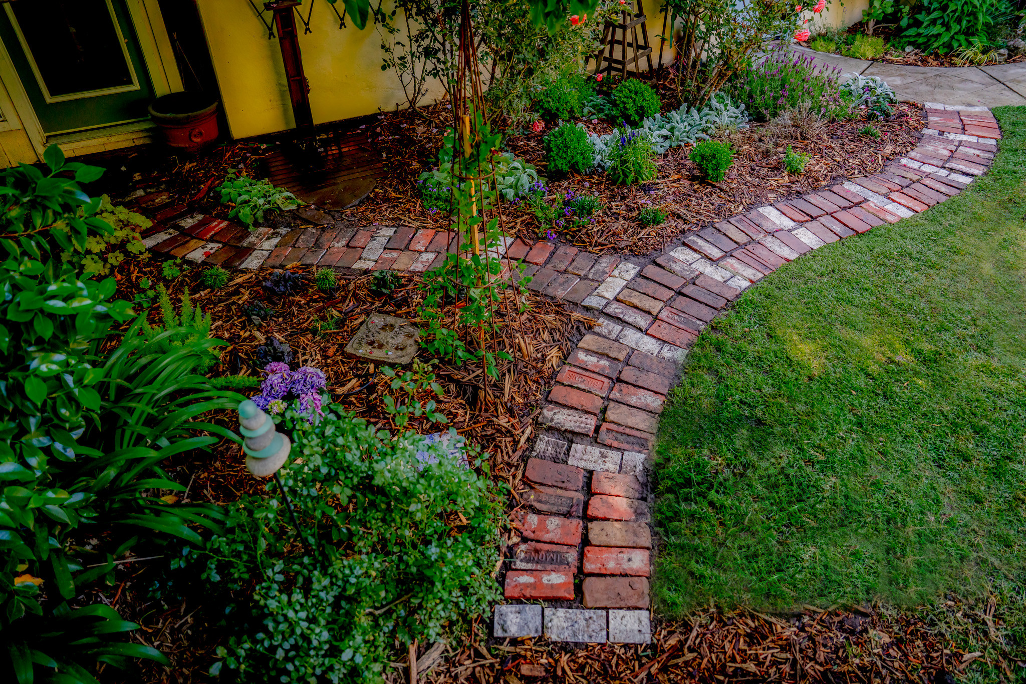 Curved Reclaimed Brick Pathway in a Layered Garden