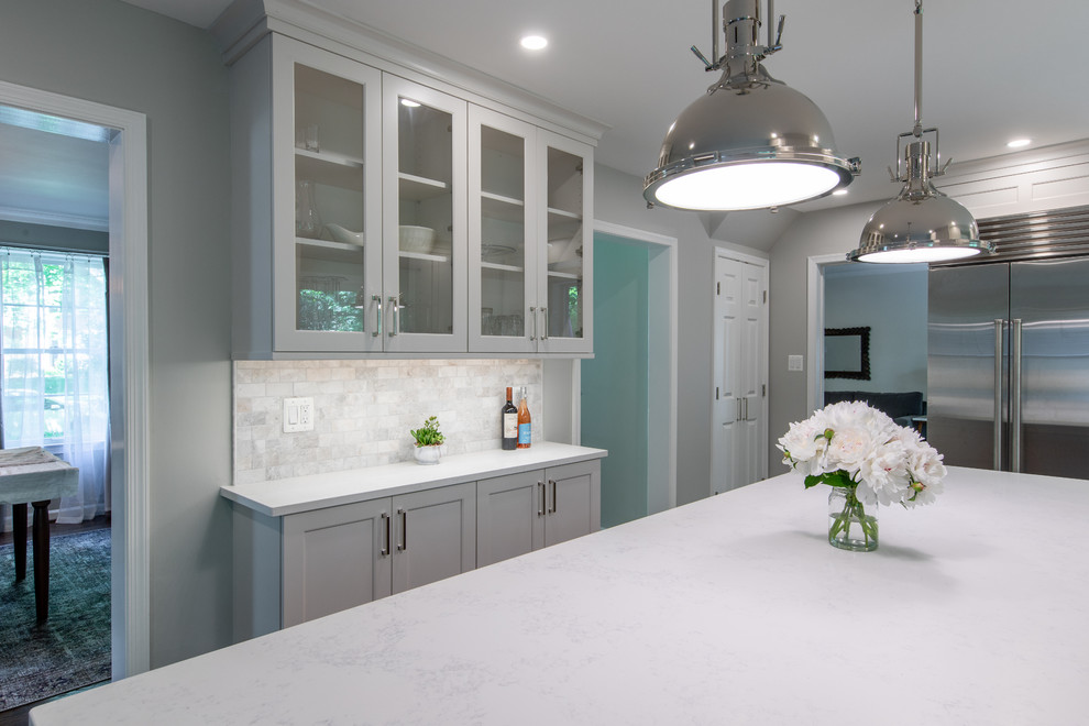 Design ideas for a mid-sized transitional kitchen in DC Metro with an undermount sink, recessed-panel cabinets, white cabinets, quartz benchtops, white splashback, marble splashback, stainless steel appliances, dark hardwood floors, with island, brown floor and white benchtop.