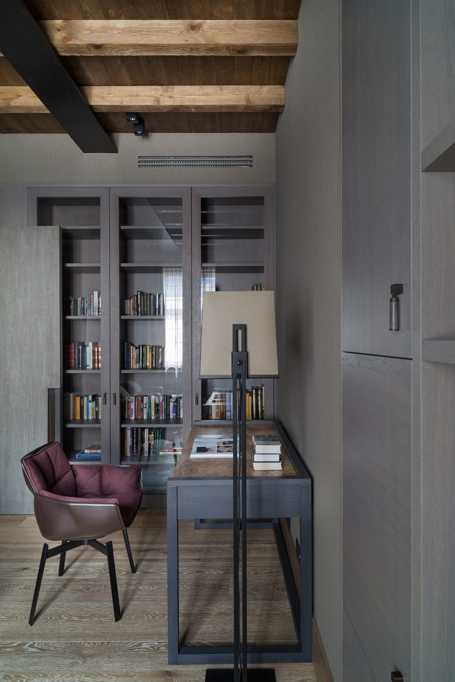 Photo of a mid-sized industrial home office in Moscow with a library and a freestanding desk.