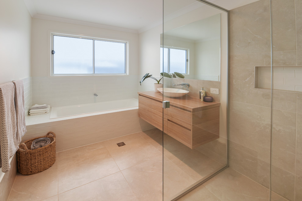 Design ideas for a beach style master bathroom in Sunshine Coast with beige tile, ceramic tile, ceramic floors, a vessel sink, beige floor, a hinged shower door, brown benchtops, a drop-in tub, flat-panel cabinets, medium wood cabinets, a corner shower, beige walls and wood benchtops.