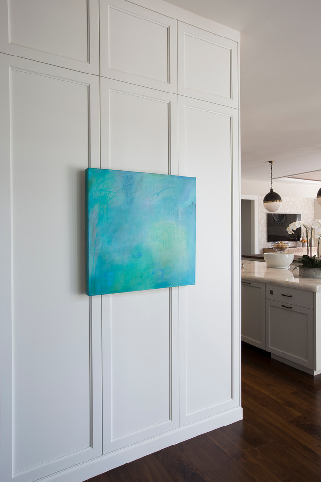 Example of a mid-sized transitional l-shaped medium tone wood floor open concept kitchen design with a single-bowl sink, shaker cabinets, white cabinets, wood countertops, white backsplash, stone slab backsplash, paneled appliances and two islands