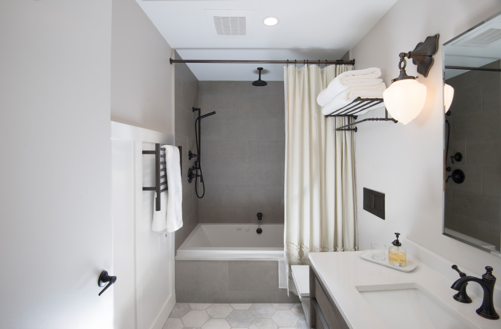 Photo of a small traditional bathroom in Other with flat-panel cabinets, medium wood cabinets, an alcove tub, a shower/bathtub combo, a wall-mount toilet, gray tile, porcelain tile, grey walls, porcelain floors, an undermount sink, quartzite benchtops, grey floor, a shower curtain, white benchtops, a single vanity, a floating vanity and decorative wall panelling.
