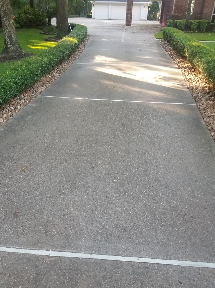 Photo of a large traditional front yard shaded driveway in Houston.