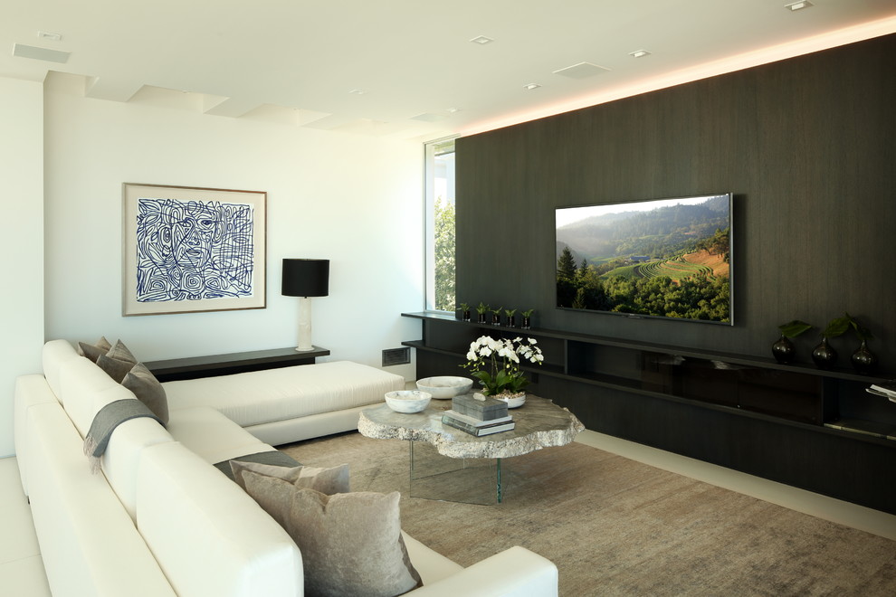 This is an example of a large contemporary enclosed family room in Los Angeles with beige walls, ceramic floors, beige floor, no fireplace and a wall-mounted tv.