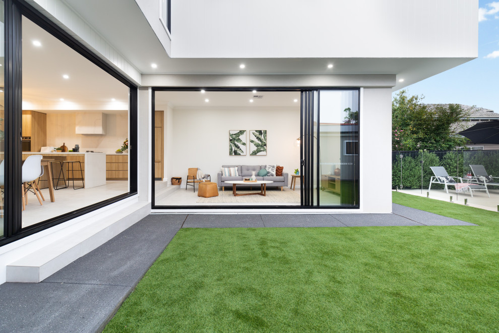 Mittelgroßes, Zweistöckiges Modernes Einfamilienhaus mit unterschiedlichen Fassadenmaterialien, weißer Fassadenfarbe, Flachdach, Blechdach, grauem Dach und Wandpaneelen in Sydney