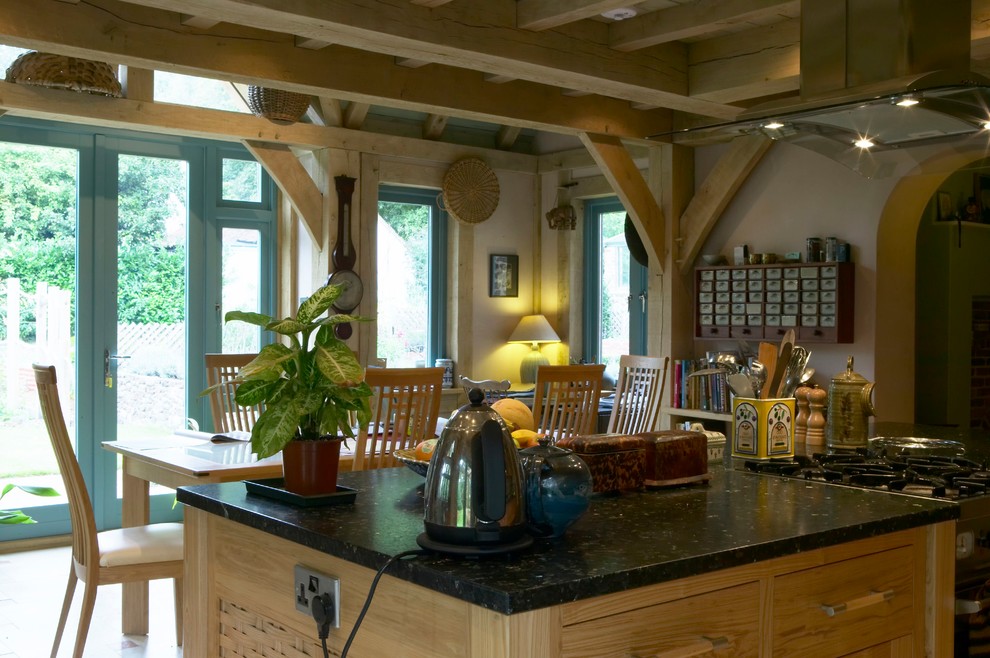 This is an example of a country eat-in kitchen in Hampshire with travertine floors.