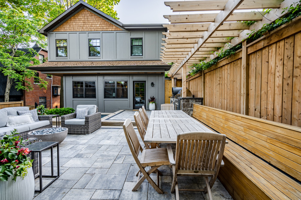 This is an example of a mid-sized transitional front yard partial sun formal garden for summer in Toronto with a garden path, concrete pavers and a metal fence.