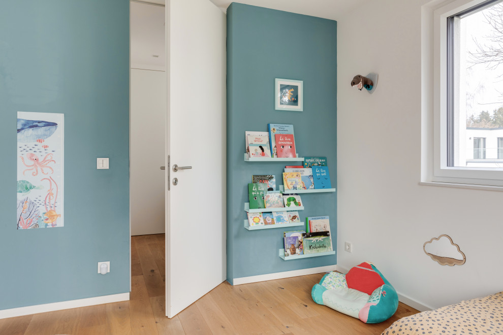 Ispirazione per una grande cameretta per bambini da 1 a 3 anni eclettica con pareti blu e pavimento in legno verniciato