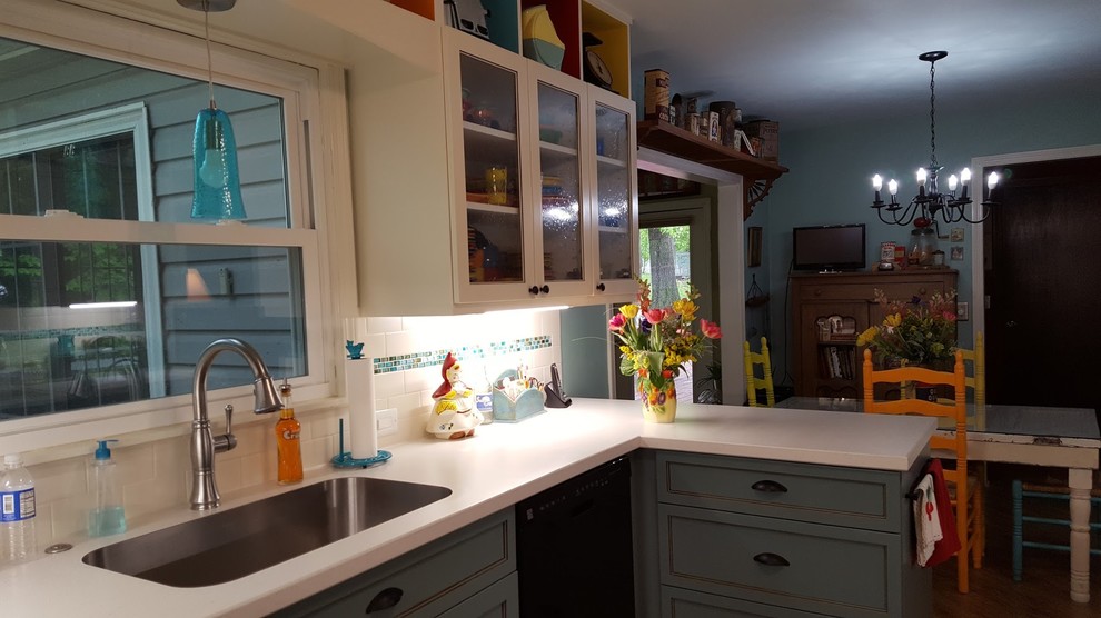 Inspiration for a mid-sized eclectic u-shaped medium tone wood floor and brown floor eat-in kitchen remodel with an undermount sink, recessed-panel cabinets, white cabinets, laminate countertops, white backsplash, subway tile backsplash, stainless steel appliances, no island and white countertops