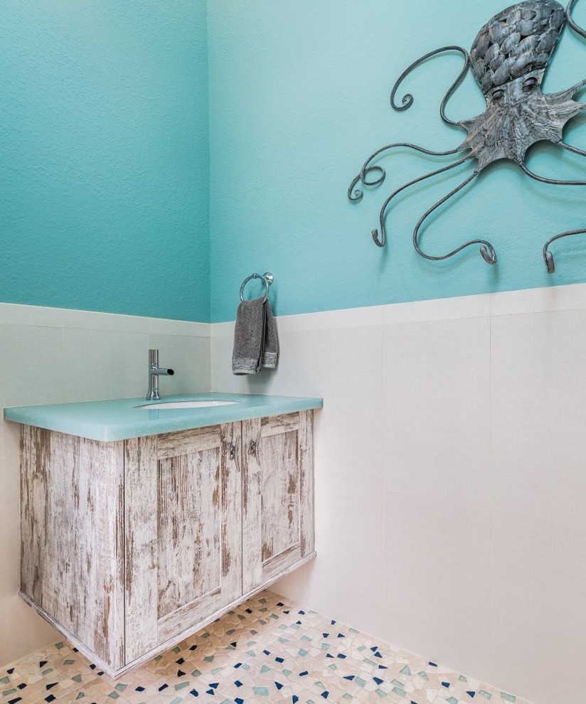 Inspiration for a mid-sized beach style 3/4 bathroom in Tampa with recessed-panel cabinets, distressed cabinets, blue tile and glass benchtops.