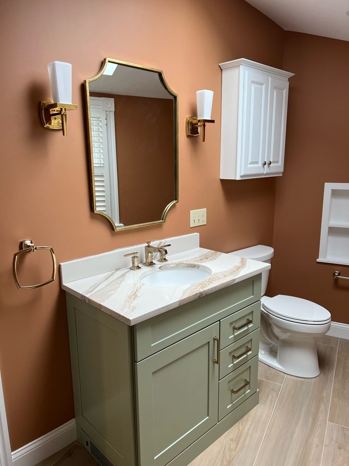 Cette photo montre une douche en alcôve chic de taille moyenne avec un placard à porte shaker, des portes de placards vertess, une baignoire en alcôve, WC à poser, un carrelage beige, un carrelage en pâte de verre, un mur marron, un sol en carrelage imitation parquet, un lavabo encastré, un plan de toilette en quartz modifié, un sol marron, une cabine de douche à porte coulissante, un plan de toilette multicolore, une niche, meuble simple vasque et meuble-lavabo encastré.