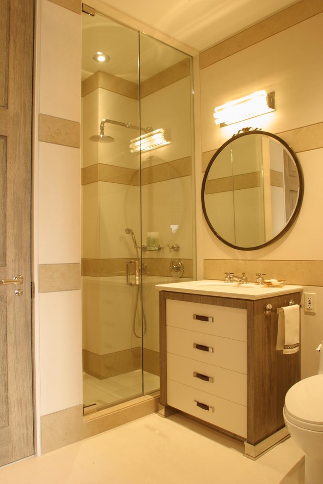 This is an example of a mid-sized contemporary 3/4 bathroom in Austin with flat-panel cabinets, white cabinets, an alcove shower, a one-piece toilet, beige tile, white tile, porcelain tile, beige walls, porcelain floors, solid surface benchtops, beige floor, a hinged shower door and an undermount sink.