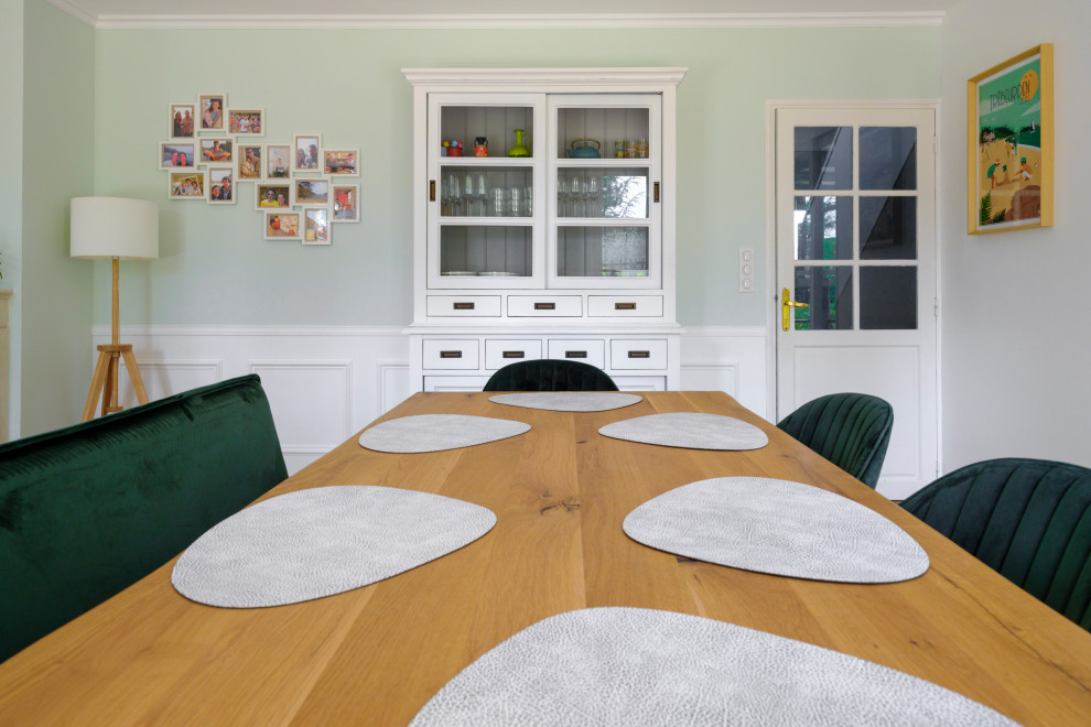 Exemple d'une salle à manger bord de mer de taille moyenne avec une banquette d'angle, un mur vert, parquet clair, une cheminée standard, un manteau de cheminée en pierre, un sol jaune et du papier peint.