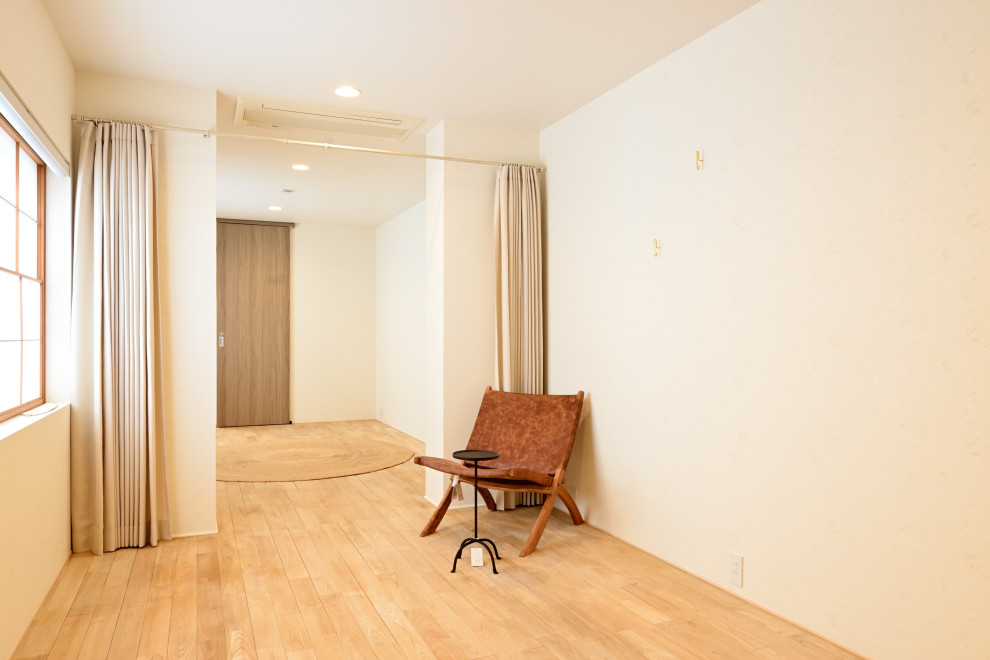 Ejemplo de salón para visitas cerrado y blanco de tamaño medio sin chimenea y televisor con paredes blancas, suelo de madera clara, suelo marrón, papel pintado y papel pintado