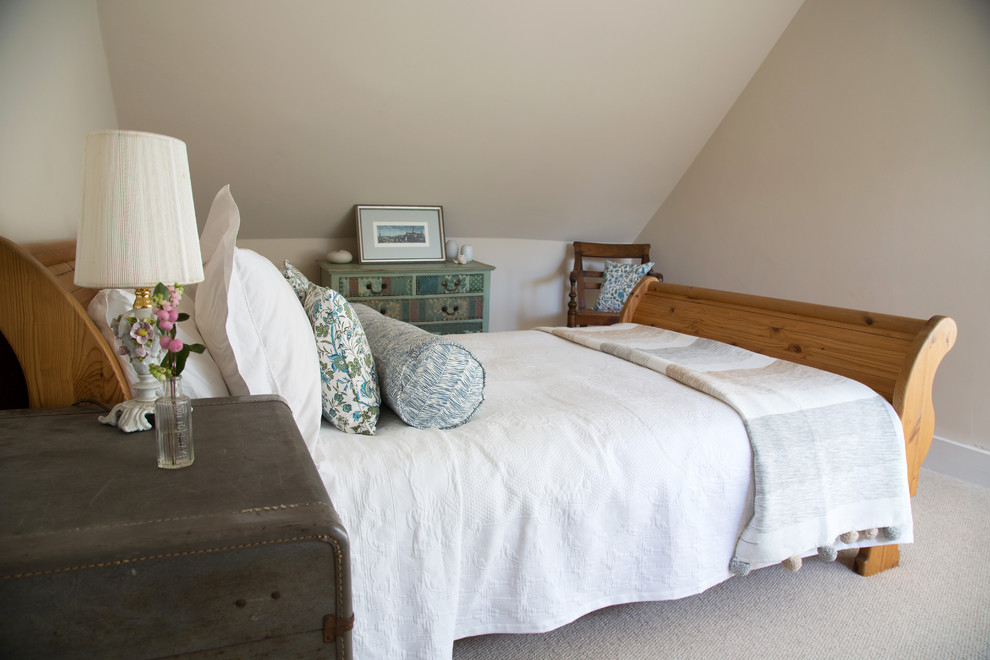 Inspiration for a mid-sized country bedroom in Kent with beige walls and carpet.