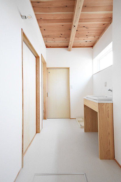 白を基調とした清潔感を感じさせる洗面脱衣室 asiatisch-gaestetoilette