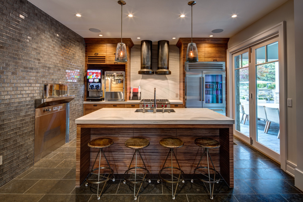 Expansive transitional single-wall seated home bar in Orange County with a drop-in sink, flat-panel cabinets, medium wood cabinets, marble benchtops, white splashback, stone slab splashback, slate floors and grey floor.