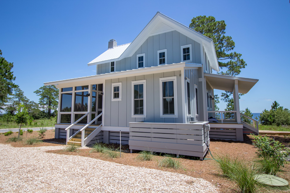 Mid-sized beach style two-storey blue house exterior in Atlanta with concrete fiberboard siding, a gable roof and a metal roof.