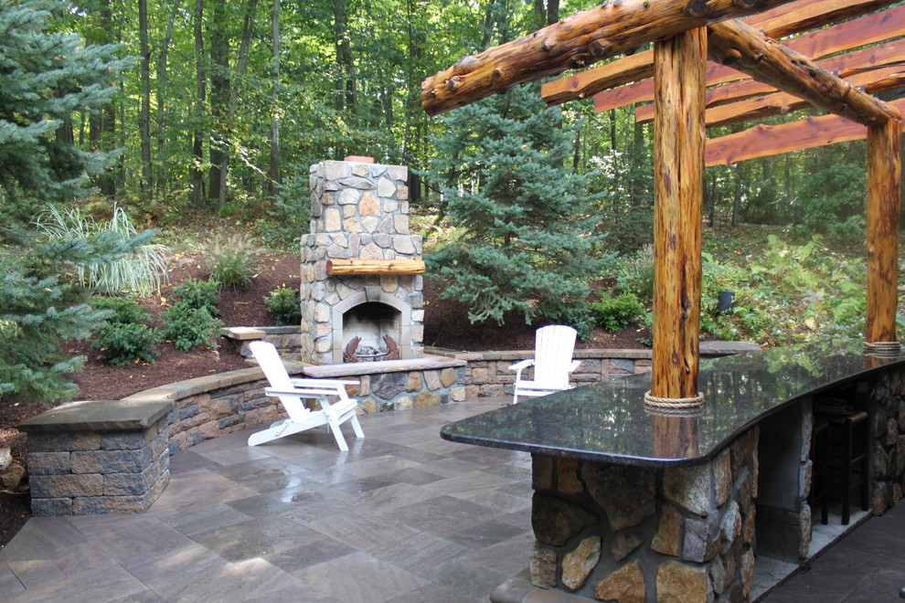 Mid-sized traditional backyard patio in New York with a fire feature, natural stone pavers and a pergola.