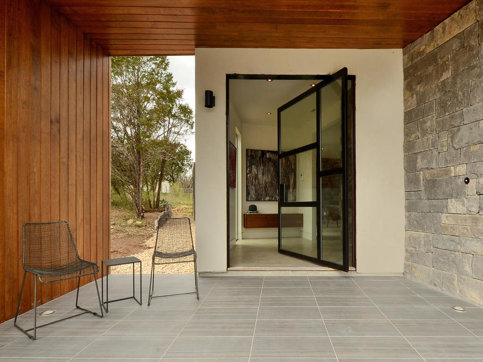 Design ideas for a contemporary front door in Austin with a pivot front door and a glass front door.