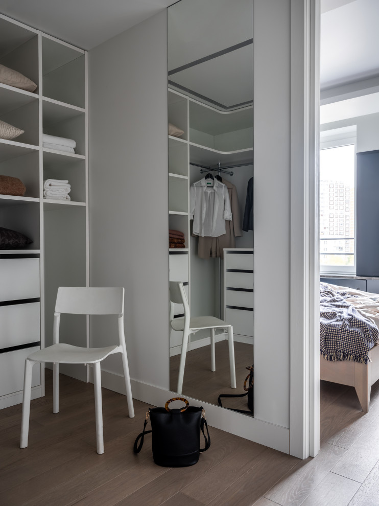 Inspiration for a large contemporary gender-neutral walk-in wardrobe in Moscow with open cabinets, medium hardwood floors, grey floor and recessed.