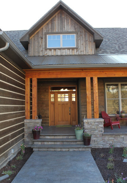 This is an example of a large country two-storey brown house exterior in Other with wood siding, a gable roof and a shingle roof.