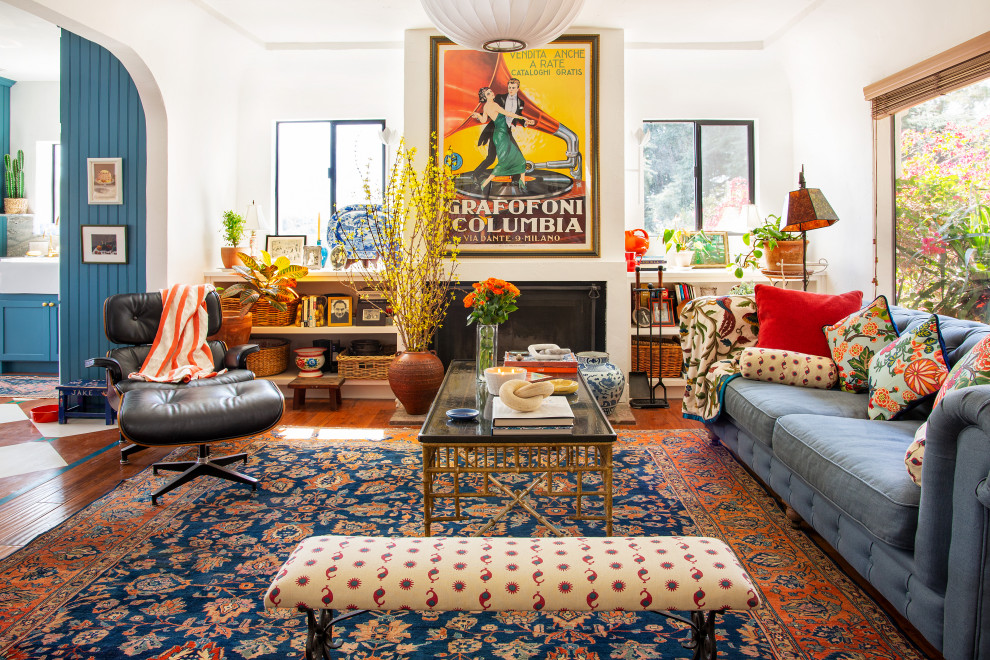 Medium sized bohemian open plan living room in Los Angeles with white walls, medium hardwood flooring, a standard fireplace, a plastered fireplace surround and brown floors.