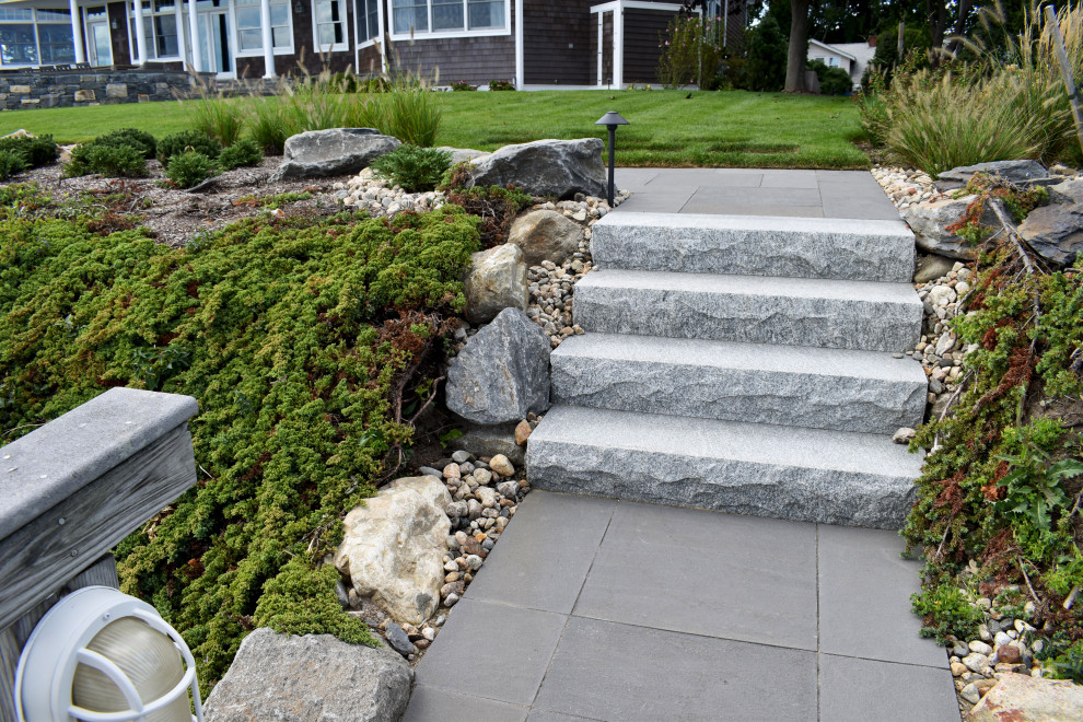 Design ideas for a large traditional sloped full sun xeriscape for summer in Providence with with rock feature and natural stone pavers.
