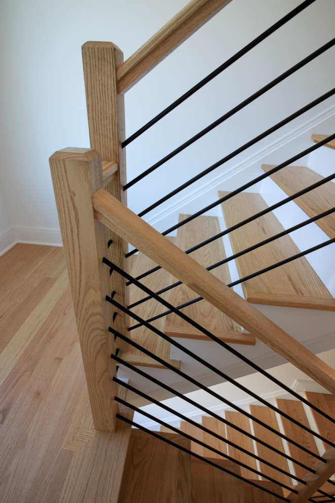 Bild på en mellanstor funkis flytande trappa i trä, med sättsteg i målat trä och räcke i flera material