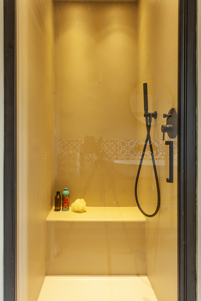 На фото: ванная комната среднего размера в средиземноморском стиле с фасадами в стиле шейкер, желтыми фасадами, душем в нише, раздельным унитазом, разноцветной плиткой, керамической плиткой, бежевыми стенами, бетонным полом, душевой кабиной, настольной раковиной, столешницей из дерева, бежевым полом, душем с распашными дверями, желтой столешницей, сиденьем для душа, тумбой под одну раковину и подвесной тумбой
