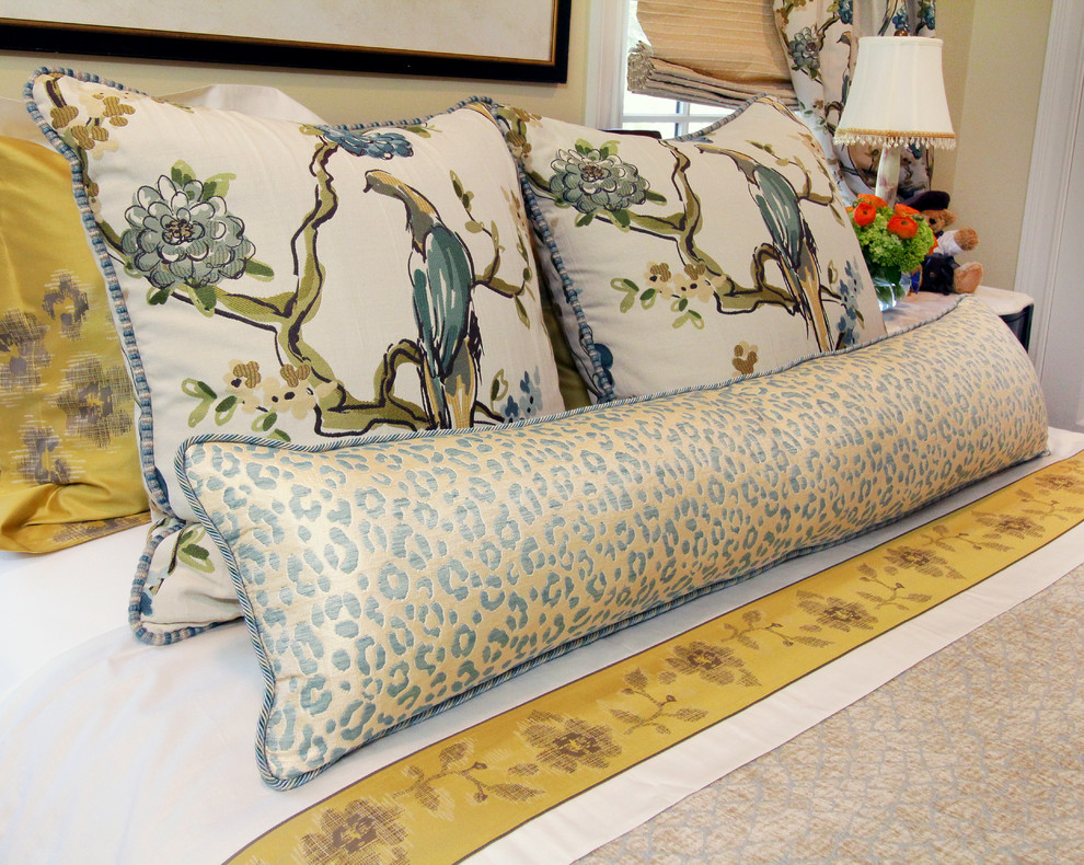 Traditional Rumson Home - A collection of custom pillows are created to adorn the bed.   The fabric on the window treatment is repeated on two oversized square pillows and a blue and gold leopard lumbar pillow sits at the forefront.