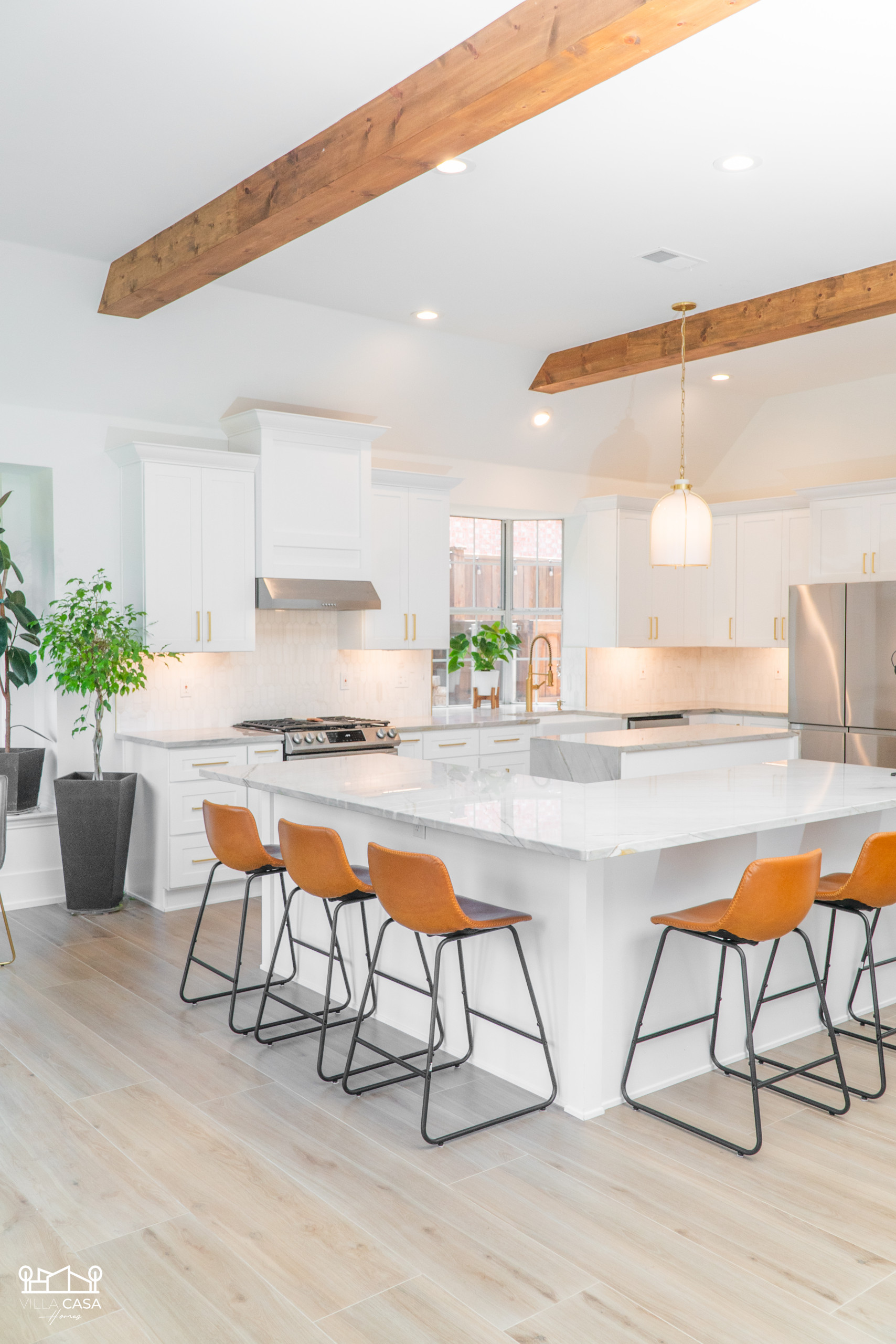 Open concept remodel allowed us to take beams from living room through kitchen - emphasizing this home's high ceilings. Kitchen features 2 islands, one for prep and one for sitting/serving. Remodel in