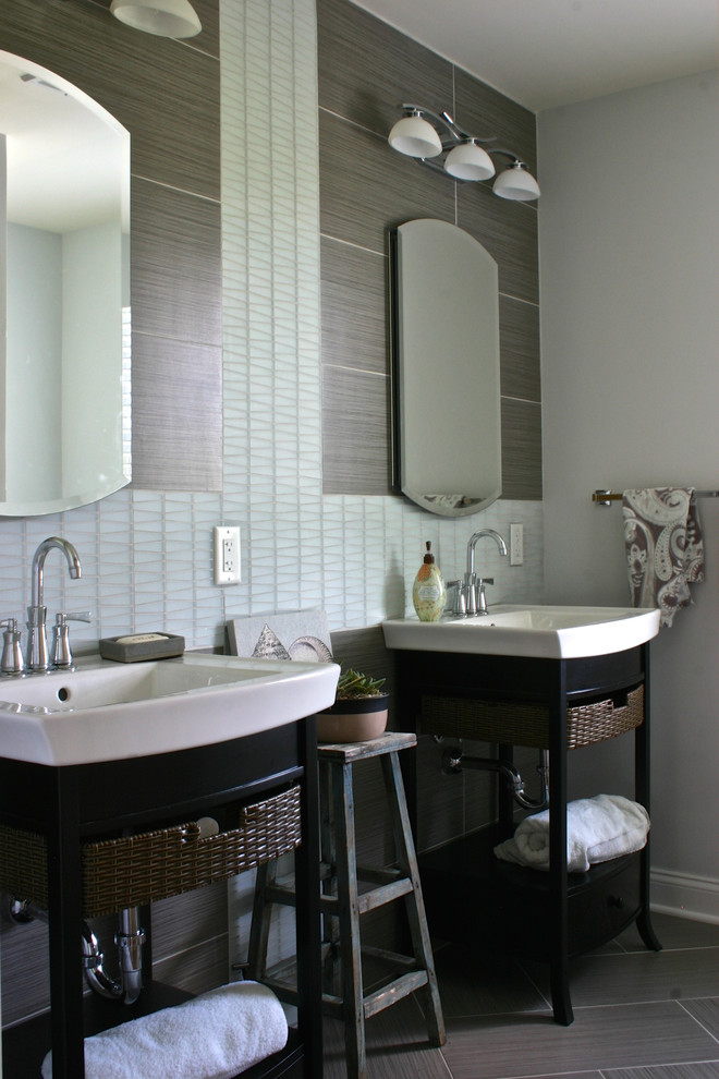 Design ideas for a mid-sized transitional master bathroom in New York with furniture-like cabinets, black cabinets, an alcove shower, gray tile, glass tile, grey walls, porcelain floors and an integrated sink.