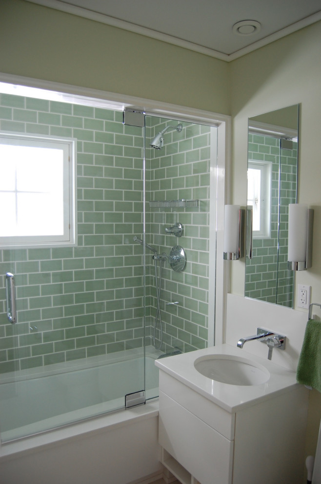 Photo of a small transitional kids bathroom in Bridgeport with flat-panel cabinets, white cabinets, an undermount tub, a shower/bathtub combo, a two-piece toilet, green tile, porcelain tile, green walls, porcelain floors, an undermount sink, quartzite benchtops, green floor, a hinged shower door, white benchtops, a single vanity and a floating vanity.