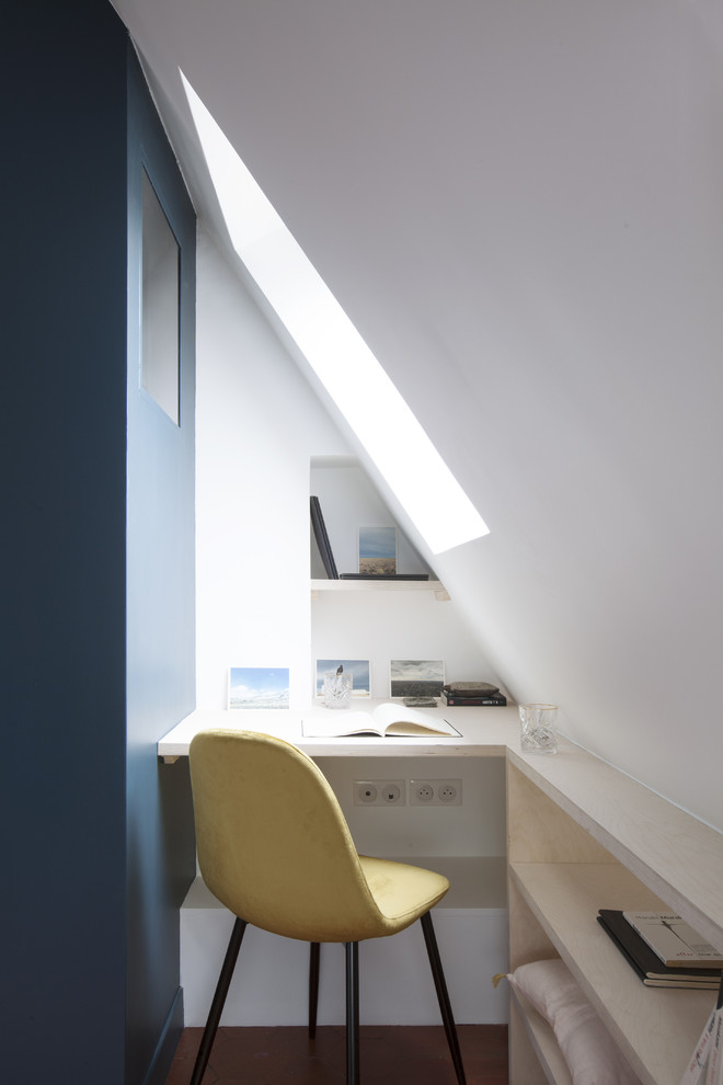 This is an example of a small contemporary study room in Paris with white walls, no fireplace, a built-in desk, brown floor and terra-cotta floors.